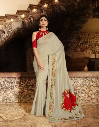 You Will Definitely Earn Lots Of Compliments Wearing This Elegant Looking Designer Saree In Pale Grey Color Paired With Red Colored Blouse. This Saree And Blouse Are Silk Based Giving A Rich Look To Your Personality. 