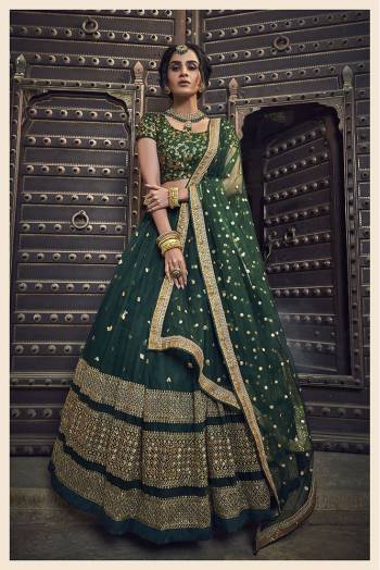 You Will Definitely Earn Lots Of Compliments Wearing This Heavy Designer Lehenga Choli In All Over Dark Green Color. This Pretty Lehenga, Choli And Dupatta Are Net based Beautified With Attractive Embroidery. 