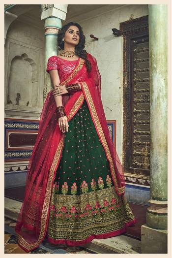 Bright And Visually Appealing Color Pallete Is Here With This Heavy Designer Lehenga Choli In Dark Pink Colored Blouse Paired with Contrasting Dark Green Colored Lehenga And Dark Pink Dupatta. This Lehenga Choli Is Net Based Beautified With Heavy Embroidery. 