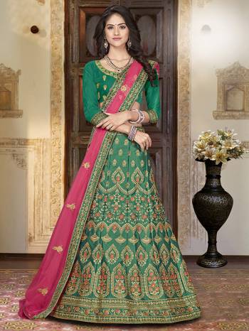 For A Proper Traditional Look, Grab This Heavy Designer Lehenga Choli In Green Color Paired With Contrasting Rani Pink Colored Blouse. Its Blouse Is Fabricated On Art Silk Paired With Satin Silk Lehenga And Net Fabricated Dupatta. It Is Beautified With Attractive Embroidery. Buy This Pretty Piece Now.?