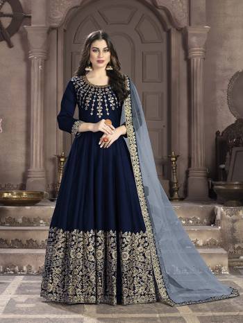 Here Is A Very Beautiful Heavy Designer Floor Length Suit In Navy Blue Color Paired With Grey Colored Dupatta. Its Top Is Fabricated On Art Silk Paired With Santoon Bottom And Net Fabricated Dupatta. It Has Heavy Embroidered Neck Line And Panel. Buy Now.