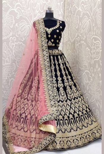 Be The Trendy Bride Wearing This Heavy designer Lehenga Choli In Navy Blue Color Paired With Contrasting Baby Pink Colored Dupatta. Its Blouse And Lehenga Are Fabricated On Velvet Paired With Net Fabricated Dupatta. Buy Now.