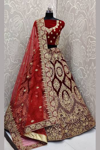 Be The Trendy Bride Wearing This Heavy designer Lehenga Choli In Maroon Color Paired With Red Colored Dupatta. Its Blouse And Lehenga Are Fabricated On Velvet Paired With Net Fabricated Dupatta. Buy Now.