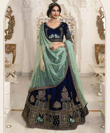 For A Royal Look, Grab This Elegant Heavy Designer Lehenga Choli In Navy Blue Color Paired With Contrasting Sea Green Colored Dupatta. This Lehenga Choli IS Fabricated On Velvet Beautified With Traditional Pattern Embroidery Paired With Net Fabricated Dupatta. Its Rich Color Pallete And Fabric Will Give A Royal Look Like Never Before. 