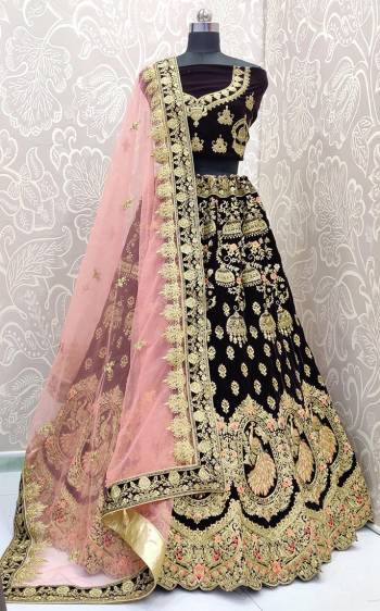 Here Is A Royal Looking Heavy Bridal Lehenga Choli In Wine Color Paired With Baby Pink Colored Dupatta. Its Blouse And Lehenga Are Fabricated On Velvet Paired With Net Fabricated Dupatta. This Designer Heavy Bridal Lehenga Choli Has Attractive Peacock Motifs. Buy Now.