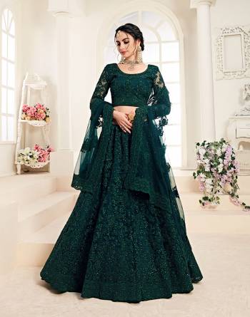 Flaunt Your Rich And Elegant Taste Wearing This Very Pretty Heavy Designer Lehenga Choli In All Over Dark Teal Green Color. This Pretty Lehenga Choli Is Fabricated On Net Paired With Net Fabricated Dupatta. It Is Beautified With Heavy Tone To Tone Embroidery Giving It A Pretty Subtle Yet Heavy Look.