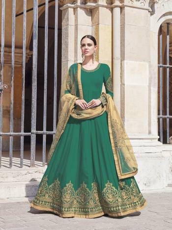 Grab This Beautiful Designer Floor Length Suit In Green Colored Top And Bottom Paired With Cream Colored Dupatta. Its Embroidered Top Is Fabricated On Georgette Paired With Satin Bottom And Net Fabricated Heavy Embroidered Dupatta. Buy This Pretty Suit Now.