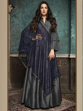 Enhance Your Personality Wearing This Designer Floor Length Suit In Dark Grey Color Paired With Contrasting Navy Blue Colored Heavy Dupatta. Its Elegant Floor Length Top Is Fabricated On Art Silk Paired With Santoon Bottom And Net Fabricated Dupatta Beautified With Heavy Stone Work. 