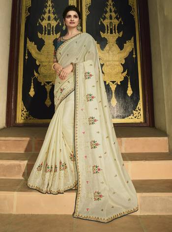 Flaunt Your Rich And Elegant Taste Wearing This Designer Saree In Cream Color Paired With Teal Blue Colored Blouse. This Saree Is Fabricated On Paper Silk Paired With Art Silk Fabricated Blouse. The Pretty Colorful Embroidery In The Saree And Blouse Gives A Lovely Look. 