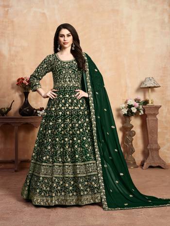 Get Ready For The Upcoming Wedding Season With This Heavy Designer Floor Length Suit In Dark Green Color. Its Heavy Embroidered Top Is Fabricated On Georgette Paired With Santoon Bottom And Georgette Fabricated Dupatta Which Has Pretty Elegant Embroidered Buttis And Lace Border. 