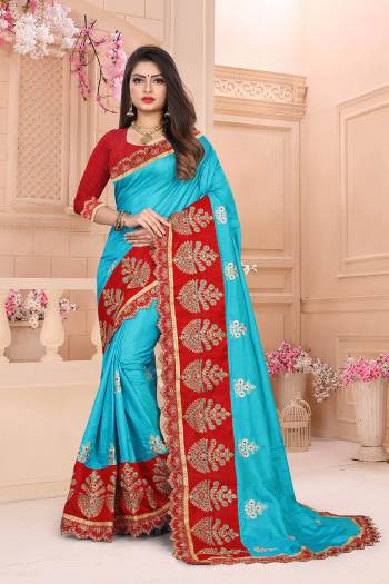 Celebrate This Festive Season With Beauty And Comfort Wearing This Designer Saree In Turquoise Blue Color Paired With Contrasting Red Colored Blouse. This Saree And Blouse Are Silk Based Which Gives A Rich Look To Your Personality. 