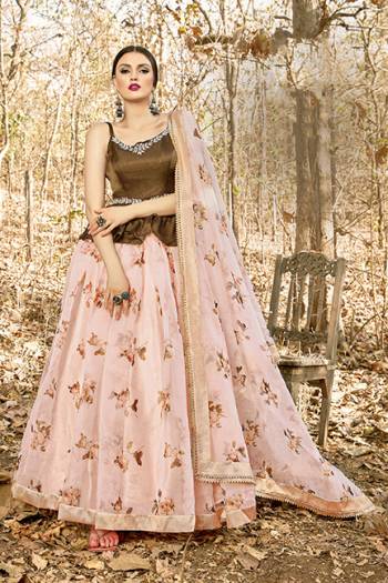 Here Is A Tendy Designer Lehenga Choli In Peplum Pattern With Brown Colored Blouse Paired With Contrasting Pastel Pink Colored Lehenga And Dupatta. Its Blouse Is Fabricated On Art Silk Paired With Orgenza Based Lehenga And Dupatta. Buy This Trendy Piece Now.