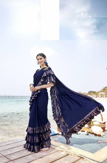 Add This Trendy Designer Ruffle Saree To Your Wardrobe In Navy Blue Color. This Pretty Saree Is Fabricated On Lycra Paired With Art Silk Fabricated Blouse. It Is Beautified With Pretty Ruffles And Hand Embroidered Patch Work. 