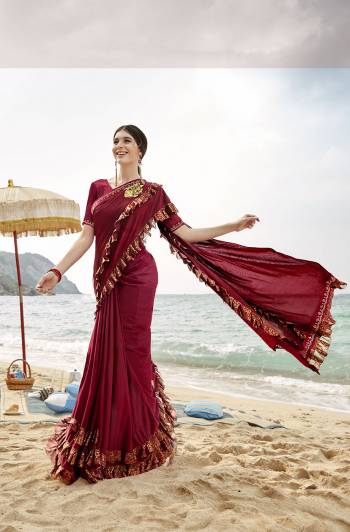 Add This Trendy Designer Ruffle Saree To Your Wardrobe In Maroon Color. This Pretty Saree Is Fabricated On Lycra Paired With Art Silk Fabricated Blouse. It Is Beautified With Pretty Ruffles And Hand Embroidered Patch Work. 