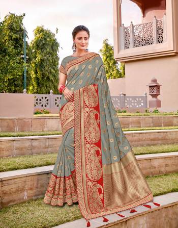 Sync to the tunes of the elegance of our traditions and let of those rhytmic vibes in this muted grey saree enhanced with a right touch of red . 