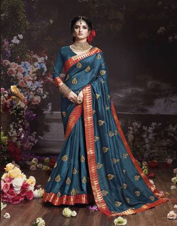 Get Ready For The Upcoming Wedding And Festive Season With This Designer Saree In Teal Blue Color. This Attractive Jari Embroidered Saree Is Fabricated On Vichitra Silk Paired With Vichitra Silk Fabricated Blouse. It Is Beautified With Broad Lace Border With Stone Work. Buy Now.