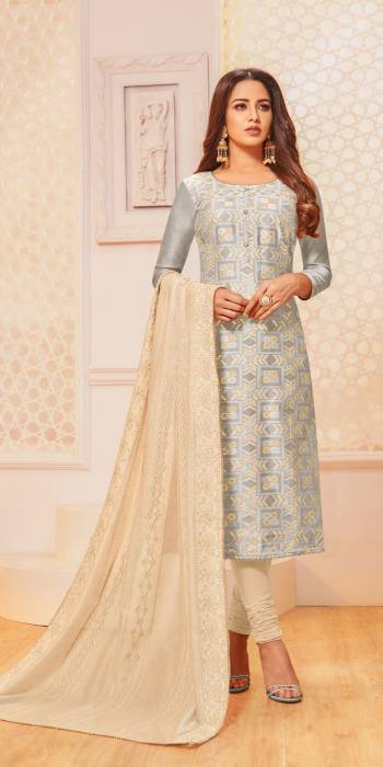 For Your Semi-Casual Wear, Grab This Pretty Semi-Stitched Suit In Light Grey Colored Top Paired With Cream Colored Bottom And Dupatta. Its Top Is Fabricated On Jacquard Silk Paired With Cotton Bottom And Chanderi Silk Dupatta. 