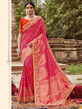 Celebrate This Festive And Wedding Season With This Heavy Designer Saree In Rani Pink Color Paired With Contrasting Orange Colored Blouse. This Pretty Saree Is Fabricated On Jacquard Silk Paired With Art Silk Fabricated Blouse.