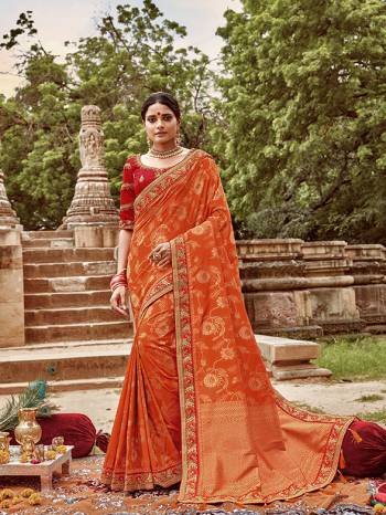 Celebrate This Festive And Wedding Season With This Heavy Designer Saree In Orange Color Paired With Contrasting Red Colored Blouse. This Pretty Saree Is Fabricated On Jacquard Silk Paired With Art Silk Fabricated Blouse.