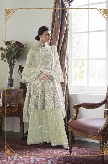 Here Is A Very Pretty And Heavy Designer Sharara Suit In All Over Pastel Green Color. Its Pretty Embroidered Top, Bottom And Dupatta Are Fabricated On Net. It Is Light In Weight And Easy To Carry Throughout The Gala. 