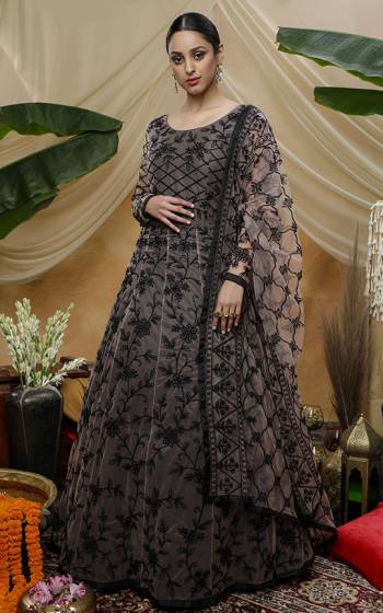 Grab This Beautiful Designer Semi-Stitched Suit In Peach And Black Color Paired With White Dupatta. This Pretty Gown Style Suit Is Fabricated On Net Beautified With Thread Embroidery. 