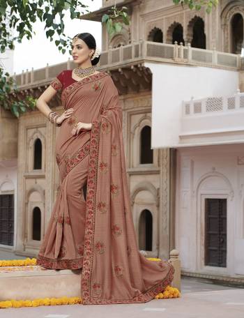 Here Is A Very Beautiful Designer Saree In Dusty Peach Color Paired With Red Colored Blouse. This Saree And Blouse Are Fabricated On Art Silk Beautified With Attractive Embroidered motifs And Lace Border. 