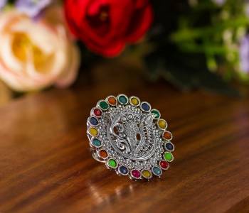 Here Is A Pretty Traditional Looking Ring In Silver Color In Oxidize Material. This Pretty Ring Is Beautified With Multi Color Stone Work And You Can Pair This Up With Any Colored Traditional Attire. Buy Now.