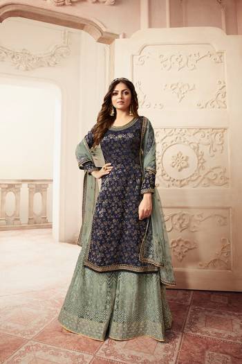 You Will Definitely Earn Lots Of Compliments Wearing This Heavy Designer Sharara Suit In Navy Blue Colored Top Paired With Dusty Blue Colored Bottom And Dupatta. Its Top Is Fabricated Jacquard Silk Paired With Net Fabricated Embroidered Bottom And Net Dupatta. 