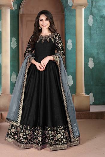 Here Is A Designer Floor Length Suit In Black Color Paired With Grey Colored Dupatta. Its Pretty Embroidered Top Is Fabricated on Slub Silk Paired With Santoon Bottom and Net Fabricated Dupatta. Buy Now.