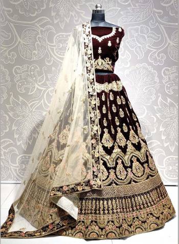 Get Ready For The Upcoming Wedding Season With This Heavy Designer Lehenga Choli In Brown Color Paired With Off-White Colored dupatta. This Lehenga Choli Is Fabricated On Velvet Paired With Net Fabricated Dupatta. 