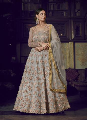 Flaunt Your Rich And Elegant Taste Wearing This Designer Semi-Stitched Floor Length Gown In Grey Color Paired With Grey Colored Dupatta. This Pretty Gown And Dupatta Are Fabricated On Net Beautified With Pretty Embroidery Giving An Attractive Look. 