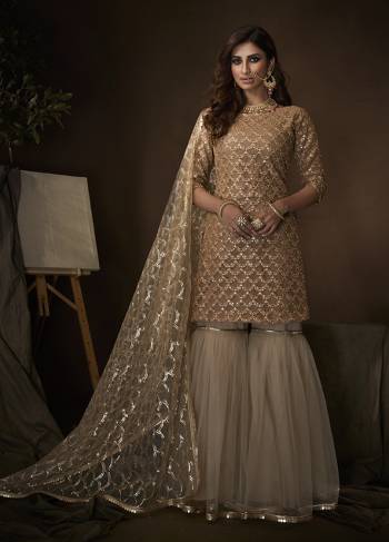 Shine Bright Wearing This Lovely Designer Sharara Suit In All Over Light Cream Color. Its Top, Bottom And Dupatta Are Fabricated On Net Beautified With Attractive Embroidery Work. Buy This Pretty Suit Now.