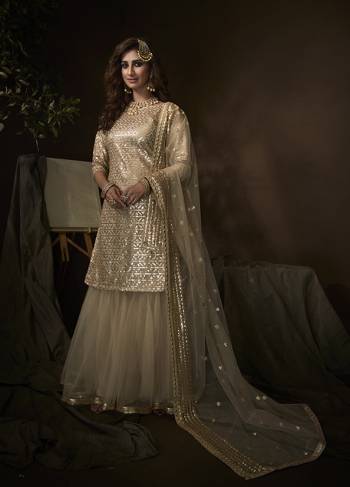 Shine Bright Wearing This Lovely Designer Sharara Suit In All Over Light Cream Color. Its Top, Bottom And Dupatta Are Fabricated On Net Beautified With Attractive Embroidery Work. Buy This Pretty Suit Now.