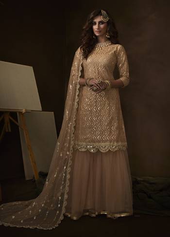 Get Ready For The Upcoming Wedding And Festive Season Wearing this Heavy Designer Sharara Suit In All Over Light Peach Color. Its Lovely Top, Bottom And Dupatta Are Fabricated On Net Beautified With Attractive Embroidery. 