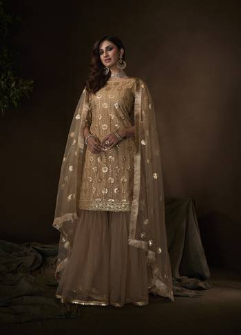 Get Ready For The Upcoming Wedding And Festive Season Wearing this Heavy Designer Sharara Suit In All Over Beige Color. Its Lovely Top, Bottom And Dupatta Are Fabricated On Net Beautified With Attractive Embroidery. 