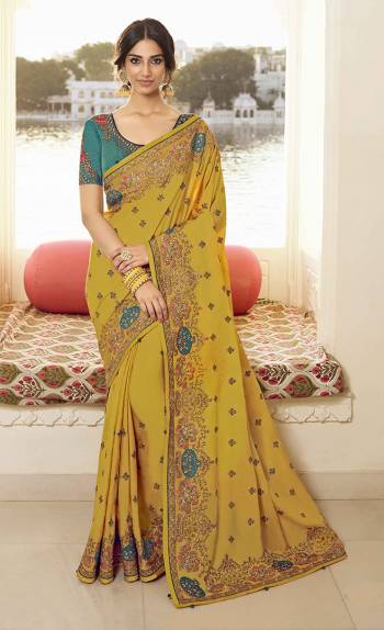 Flaunt Your Rich And Elegant Taste Wearing This Pretty Designer Saree In Yellow Color Paired With Teal Blue Colored Blouse. This Saree Is Fabricated On Vichitra Silk Paired With Art Silk Fabricated Blouse. It Is Beautified With Attractive Detailed Embroidery.  