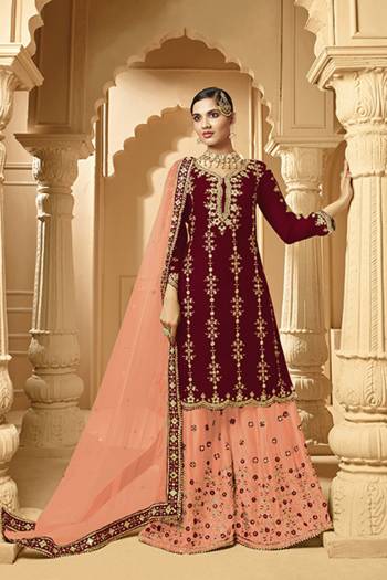 Here Is A Very Beautiful Designer Heavy Suit In Maroon Color Paired With Peach Colored bottom And Dupatta. Its Embroidered Top And Bottom Are Georgette Based Paired with Net Fabricated Dupatta. 