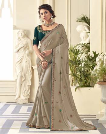 Get Ready For the Upcoming Wedding And Festive Season Wearing This Beautiful Designer Embroidered Saree In Light Grey Color Paired With Contrasting Teal Green colored Blouse. This Saree Is Fabricated On Satin Silk Paired With Art Silk Fabricated Blouse. Its Rich Fabric And Color Will Earn You Lots Of Compliments From Onlookers. 