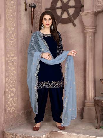 Here Is A Very Pretty Designer Suit In Navy Blue Color Paired With Paired With Baby Blue Colored Dupatta. Its Embroidered Top Is Fabricated On Velvet Paired With Santoon Bottom And Net Fabricated Dupatta. This Pretty Suit Is Light In Weight And Easy To Carry All Day Long. 