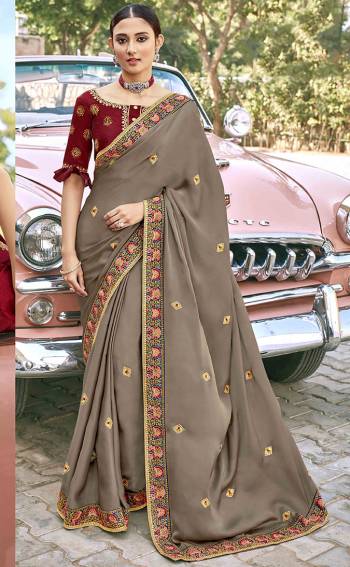 Look Attractive Wearing This Grey Colored Saree Paired With Maroon Colored Blouse.  This Heavy Designer Saree Is Silk Based Which Gives A Rich Look To Your Personality. Buy This Pretty Saree Now.